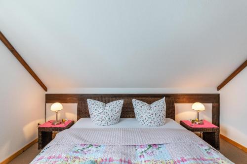 a bedroom with a bed with two lamps on tables at Atlanta Pur in Pellworm