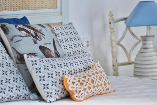 a group of pillows on a bed with a blue lamp at El Patio del Limonero in Écija