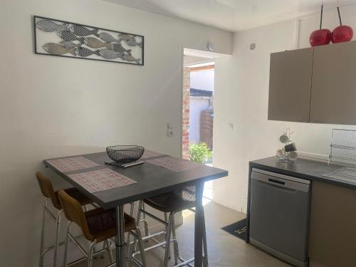 - une cuisine avec une table, des chaises et un comptoir dans l'établissement Maison de pêcheurs à Dieppe, à Dieppe