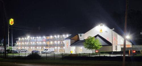 a large white building with lights on it at night at Super 8 by Wyndham Vandalia/Dayton International Airport in Vandalia