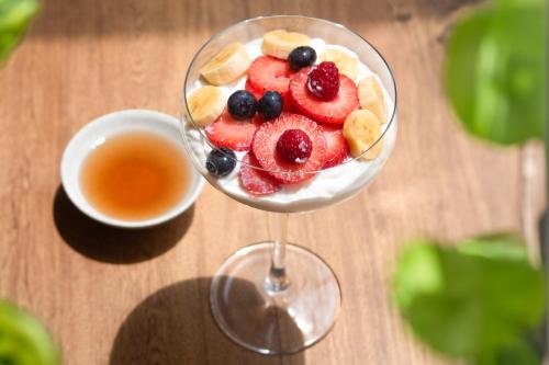 a glass of fruit salad with a cup of tea at Urbit Social Lofts in Medellín