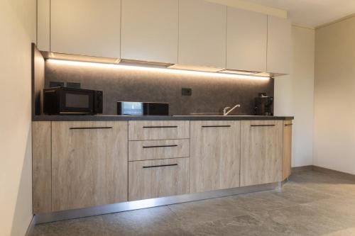 een keuken met een spoelbak en een magnetron bij Baita della Valle -Appartamento Bucaneve- in Livigno