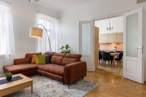 a living room with a brown couch and a table at K1820 Family apartments in Rīga