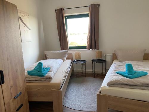 Neu GaarzGroßes Familienapartment über 2 Etagen mit Weitblick in die Natur的客房内的两张床,上面有蓝色的毛巾