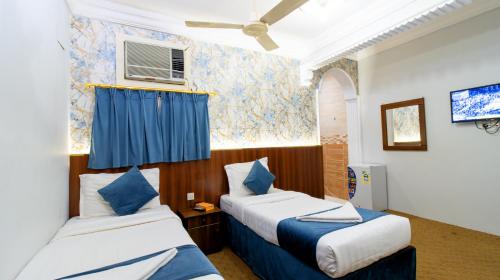 a hotel room with two beds and a window at فندق برادايس نيس النزهة Paradise Nice Hotel in Mecca