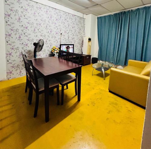 a living room with a table and a couch at Bilik Bajet BDS in Temerloh