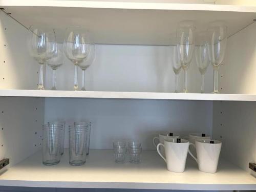 a row of wine glasses and cups on a shelf at City Apartment Cologne in Cologne