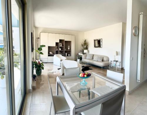 - un salon avec une table en verre et un mobilier blanc dans l'établissement Manon B&B, à Roquebrune-Cap-Martin