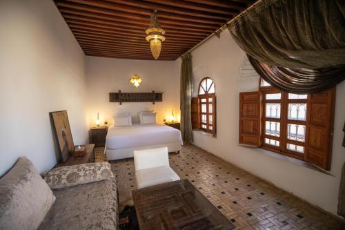 a bedroom with a bed and a couch in a room at Riad Layla in Fez