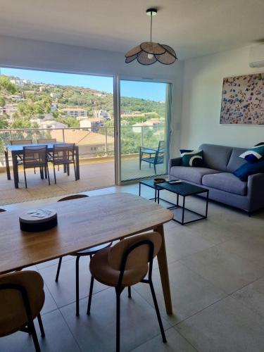 un salon avec une table et un canapé dans l'établissement Bel appartement neuf-4 personnes, à LʼÎle-Rousse