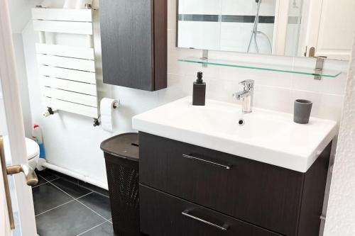 ein Badezimmer mit Waschbecken und Spiegel in der Unterkunft Bel Appartement Moderne TOP emplacement pour 4Pers et 2ch in Montigny-lès-Metz