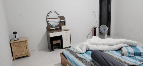 a bedroom with a bed and a mirror and a dresser at Nhà du lịch nguyên căn in Khu Chi Lăng