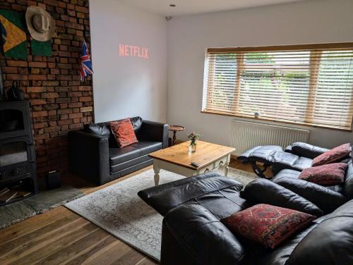 a living room with a couch and a table at 4bedrooms house sleeps14 Garden&Parking Ably Stays in London