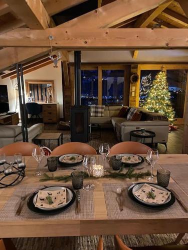 - une table avec des assiettes, des verres à vin et un sapin de Noël dans l'établissement Chalet Aspre, à Samoëns