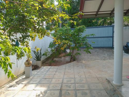 a patio with two trees and a fence at Mihinsa Guest in Kosgoda