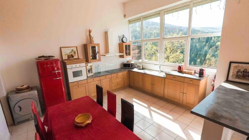 une cuisine avec une table et un réfrigérateur rouge dans l'établissement Gite74, Gite du MontBlanc, GLMB, à Saint-Gervais-les-Bains