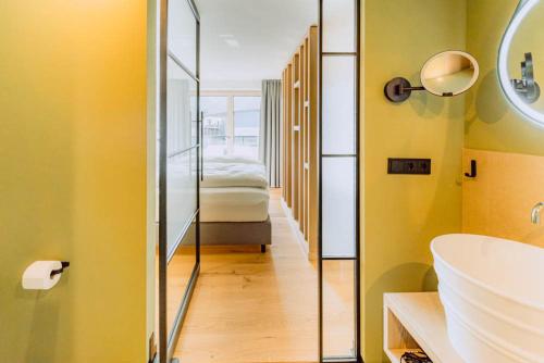 a bathroom with a sink and a bed in a room at KABINETT Boutique Apartments in Kröv