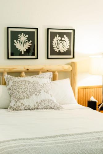 a bedroom with a bed with two pictures on the wall at Sylvan Valley Lodge and Cellars in Sautee Nacoochee