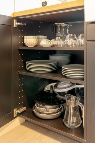 a cabinet filled with plates and bowls and dishes at Charmant gîte cosy et romantique à Sanguinet in Sanguinet