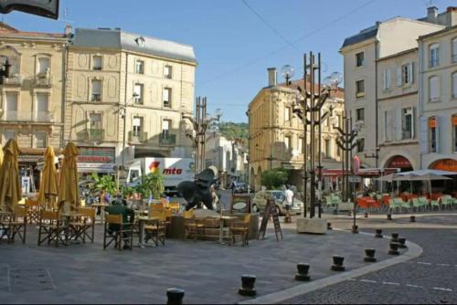 une place de la ville avec des tables, des chaises et une statue dans l'établissement T2 coeur de ville, wifi, netflix, à Agen
