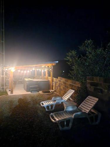 a group of benches in front of a building at night at Bucovina-MountainHouse-5BR-Fireplace-HotTub-WiFi in Suceviţa