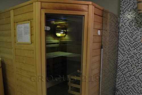 a wooden cabinet with a glass door in a bathroom at Apartmán Štrbské Pleso - Crocus 219 in Štrbské Pleso