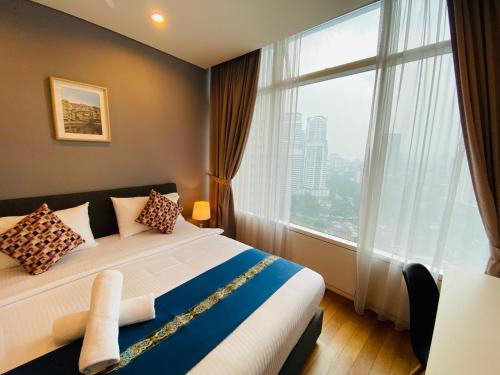 a bedroom with a bed and a large window at APARTMENT VorteX KLCC in Kuala Lumpur