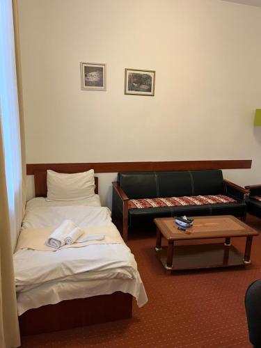 a room with two beds and a couch and a table at Diligence Hotel & restaurant in Dilijan