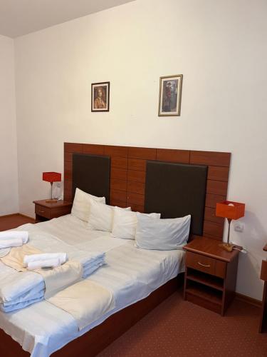 a bedroom with two beds with white sheets at Diligence Hotel & restaurant in Dilijan