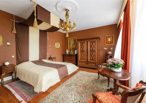 une chambre avec un lit et une table dans l'établissement Château Picol entre Futuroscope et Châteaux de la Loire, à Boussageau