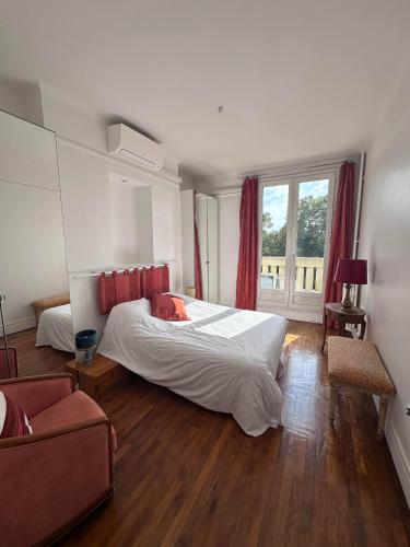 une chambre avec un lit, un canapé et une fenêtre dans l'établissement Luxueux appartement à la Porte d'Auteuil - 16ème Arrondissement, à Paris