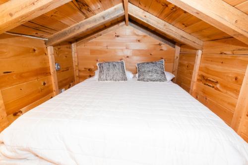 a bed in a small room in a wooden cabin at Sylvan Valley Lodge and Cellars in Sautee Nacoochee