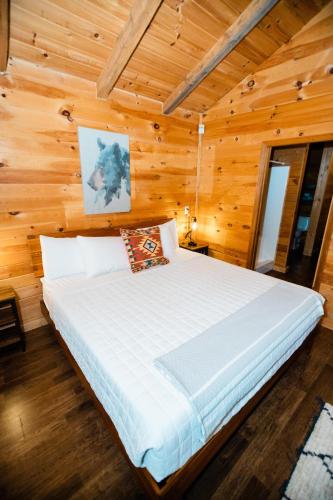 a bedroom with a bed in a wooden cabin at Sylvan Valley Lodge and Cellars in Sautee Nacoochee