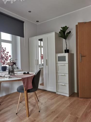 a white kitchen with a table and a desk at Pokoje gościnne Kamil 2 in Karpacz