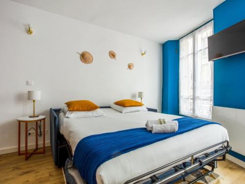 - une chambre avec un grand lit aux accents bleus dans l'établissement Le Cessac - Versailles, à Versailles