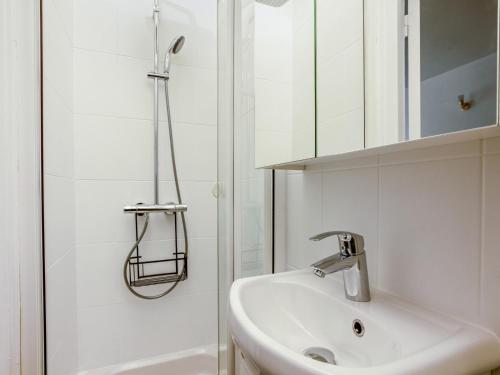 une salle de bain blanche avec un lavabo et une douche dans l'établissement Le Cessac - Versailles, à Versailles