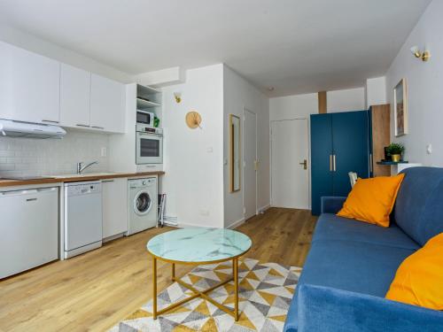 un salon avec un canapé bleu et une table dans l'établissement Le Cessac - Versailles, à Versailles