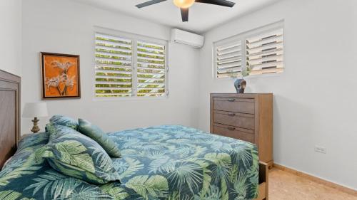 a bedroom with a bed and a ceiling fan at Casita 3 at Ceiba Tree Inn. Tranquility with Garden Views and Pergola with Ocean Overlook in Rincon