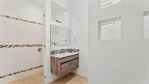 a white bathroom with a sink and a mirror at Casita 3 at Ceiba Tree Inn. Tranquility with Garden Views and Pergola with Ocean Overlook in Rincon
