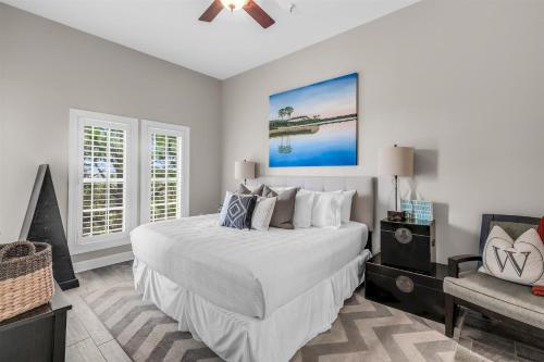 a bedroom with a large white bed and a couch at Seacrest - The Wellington in Panama City Beach