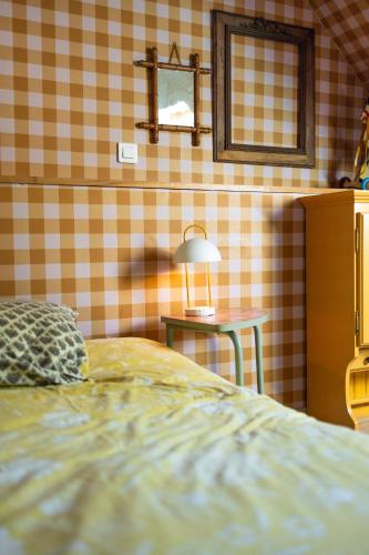 a bedroom with a bed and a table with a lamp at Si Long va bien in Long