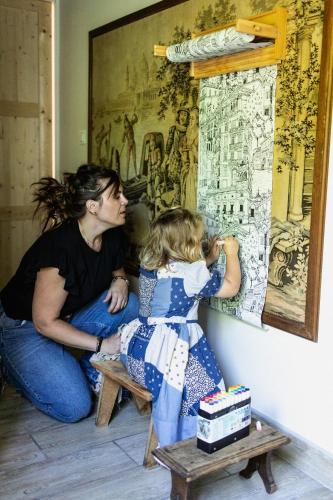 a woman and a little girl painting a wall at Si Long va bien in Long
