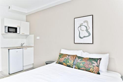 - une chambre blanche avec un lit et un four micro-ondes dans l'établissement Petit studio moderne à Asnières, à Asnières-sur-Seine