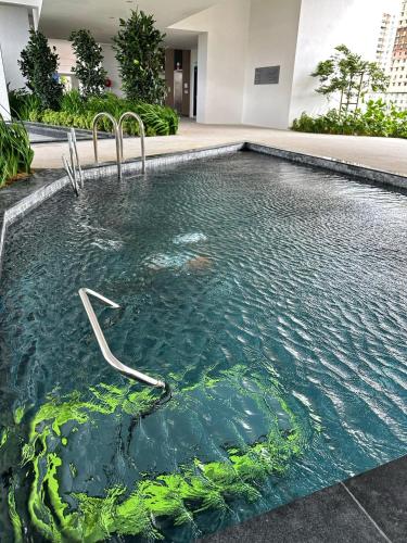a swimming pool in a building with green algae at Cozy Urban Suites Georgetown View in Jelutong