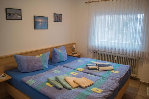 a bedroom with a bed with towels and a window at Ferienwohnung Bäumer Borkum - Nichtraucher & allergikerfreundlich in Borkum