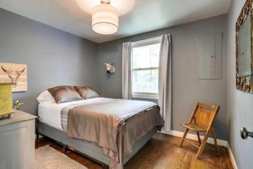 une chambre avec un lit, une fenêtre et une chaise dans l'établissement Franklin Cottage Cozy 2 bed 1 bath, à Franklin