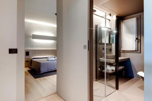 una camera con letto e porta a vetri con specchio di Mima Aparthotel Boutique & Spa a Milano Marittima