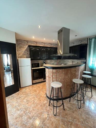 - une cuisine avec un bar avec des tabourets dans l'établissement Maison Centre ville 3 chambres, à Calais