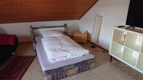 a small bedroom with a bed and a tv at Ferienwohnung in Ländliche Gegend die zum Verweilen einlädt in Wachenroth