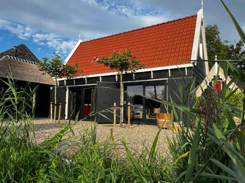 an extension to a house with an orange roof at Luxury private farmhouse cottage near Amsterdam plus home cinema in Ilpendam